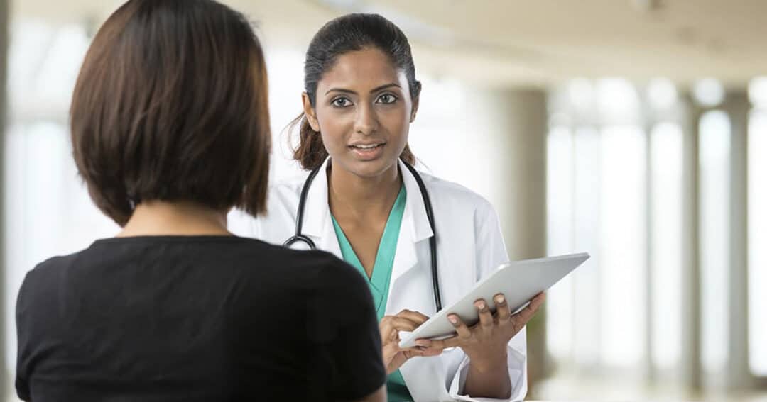 Concept image of a patient registering with a caregiver to see if they're eligible for a clinical trial.